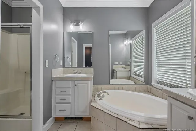 a bathroom with a tub a double vanity sink and mirror