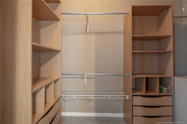 a view of walk in closet with empty racks