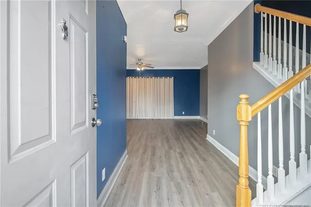 a view of a hallway with wooden floor and staircase