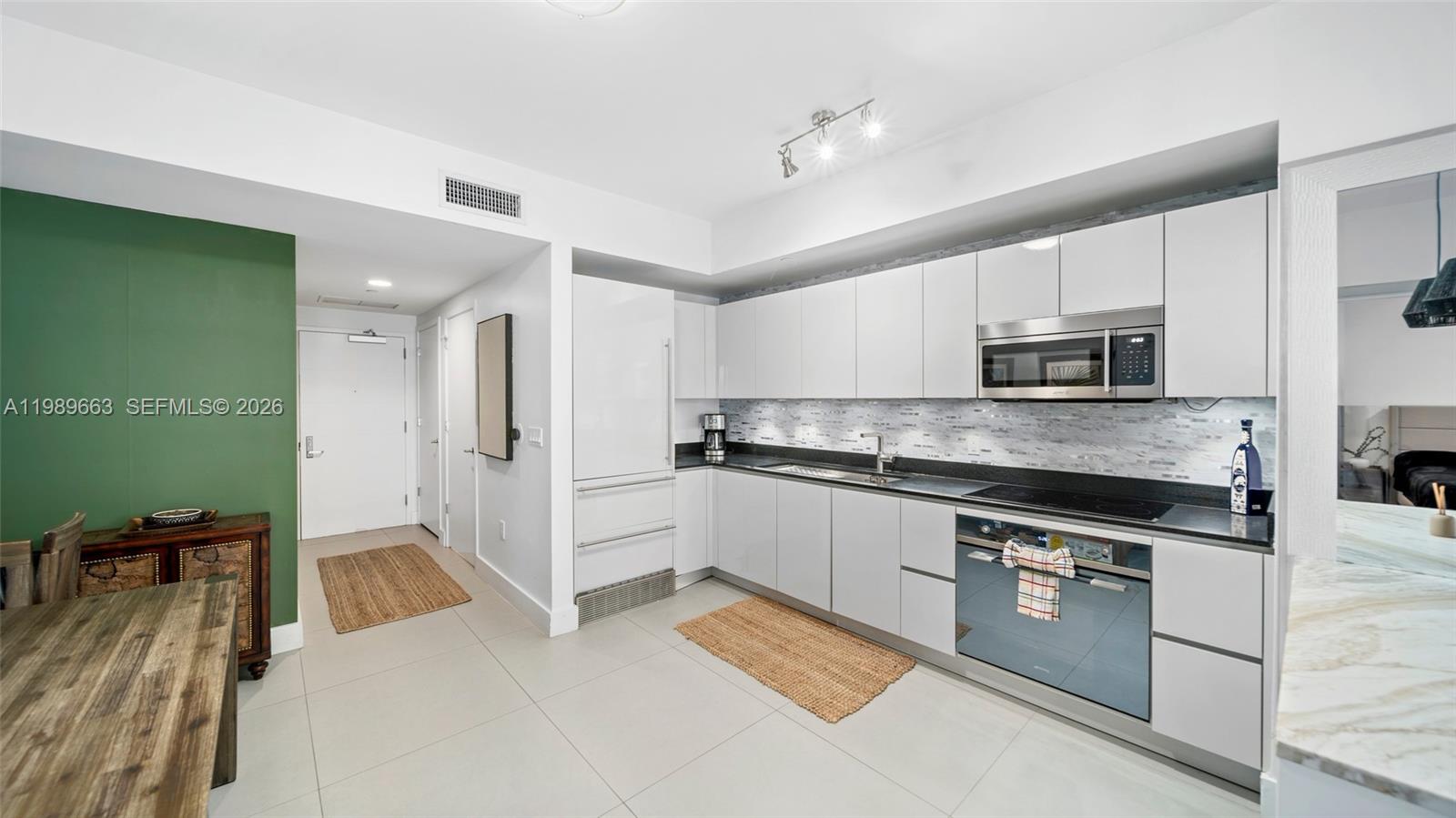 1010 Brickell Avenue, Unit 2008 Miami, FL 33131 - Photo 4 of 26 a kitchen with stainless steel appliances granite countertop a refrigerator and a stove top oven