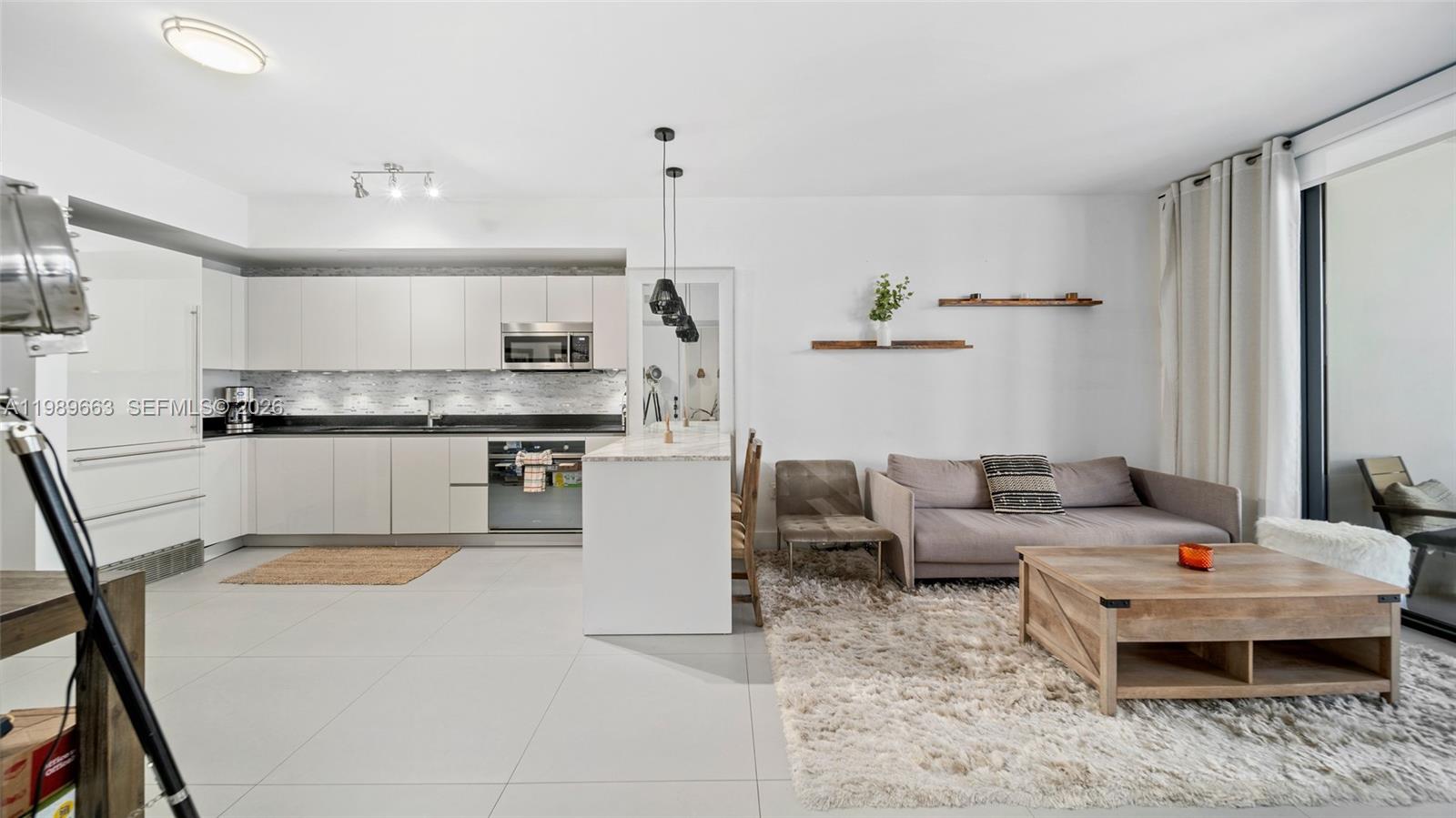 1010 Brickell Avenue, Unit 2008 Miami, FL 33131 - Photo 6 of 26 a kitchen with stainless steel appliances kitchen island granite countertop a sink dishwasher a stove and white cabinets with wooden floor