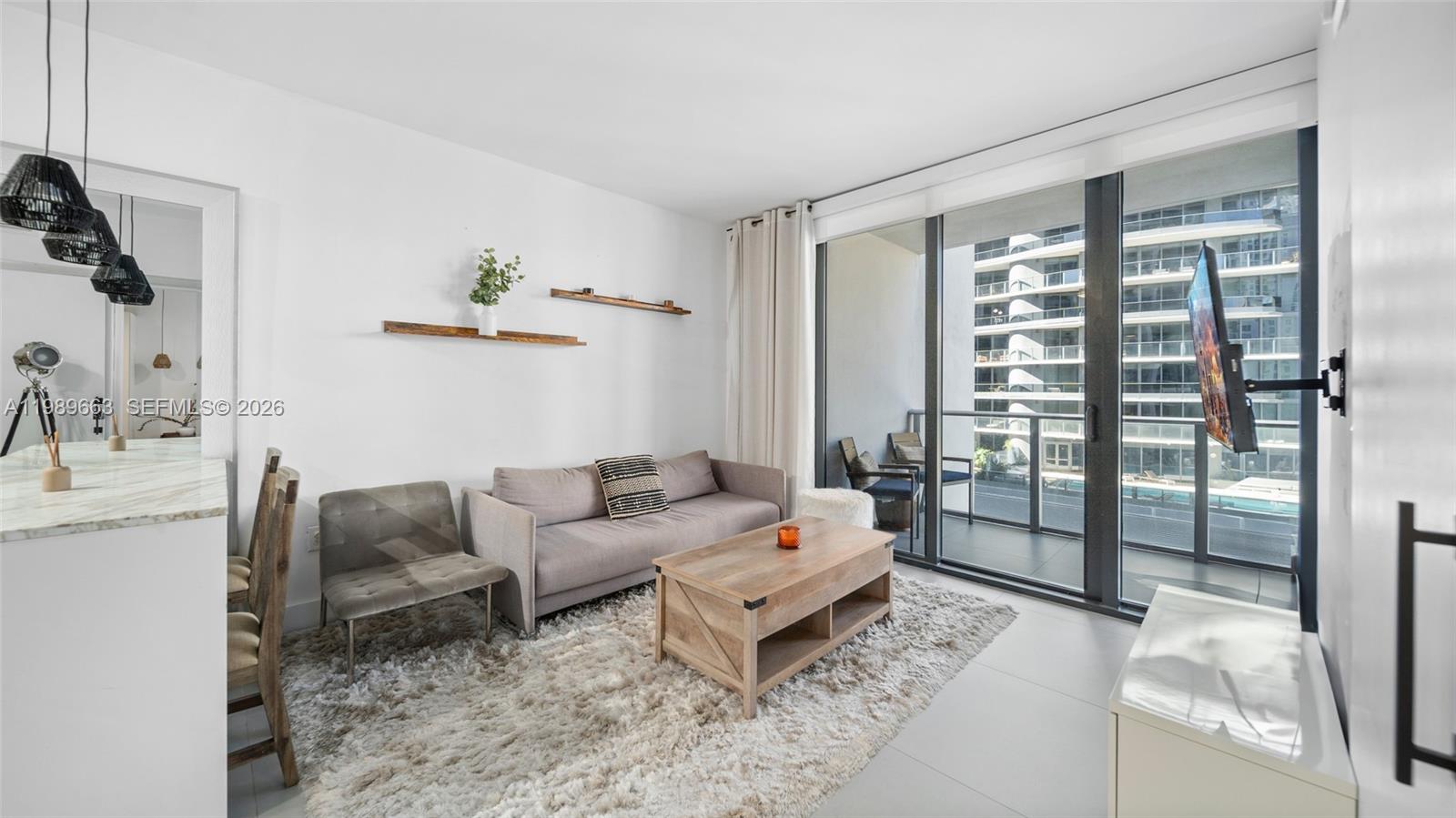 1010 Brickell Avenue, Unit 2008 Miami, FL 33131 - Photo 7 of 26 a living room with furniture and a floor to ceiling window