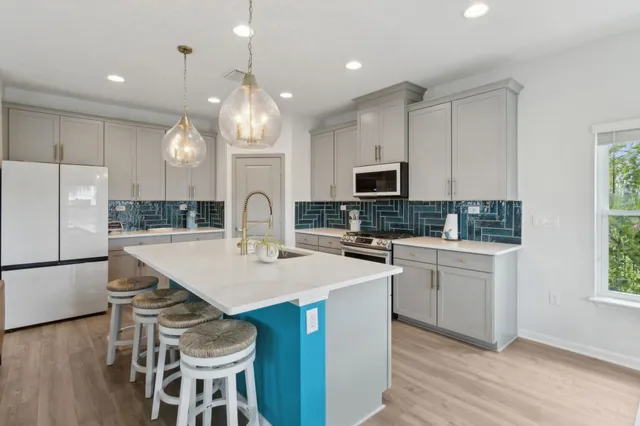 a kitchen with sink a microwave and refrigerator