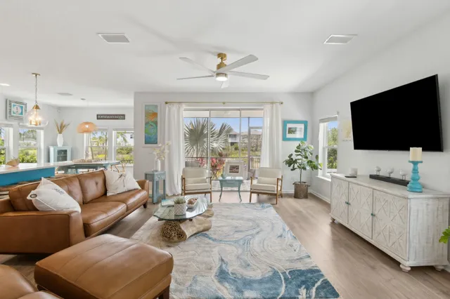 a living room with furniture a flat screen tv and a large window