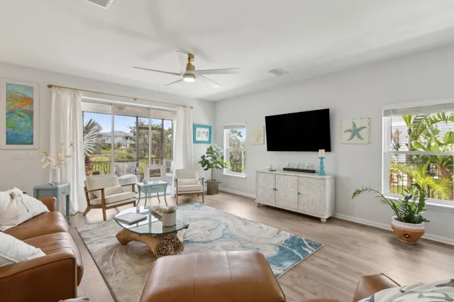 a living room with furniture a flat screen tv and a large window