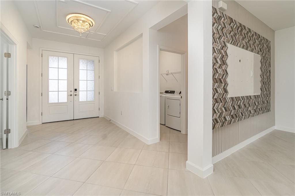 11127 Canopy Loop Fort Myers, FL 33913 - Photo 2 of 29 Foyer entrance featuring hanging lights, washing machine and clothes dryer, light tile patterned flooring, and french doors