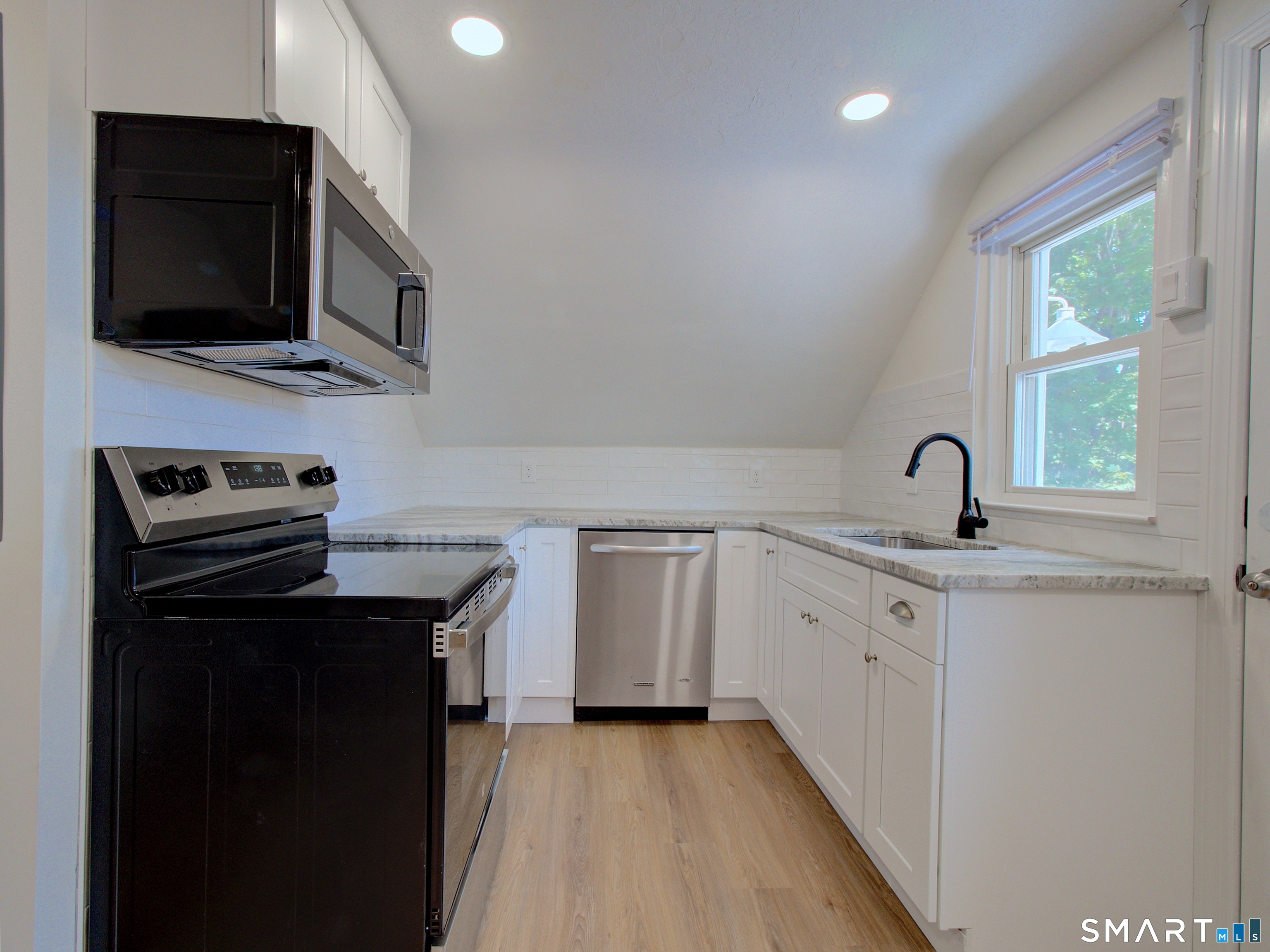 16 Benham Road, Unit D Groton, CT 06340 - Photo 9 of 15 a kitchen with stainless steel appliances a stove microwave and sink