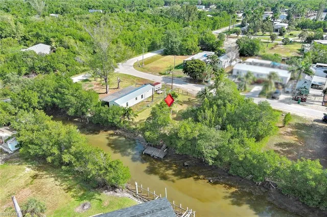 an aerial view of residential houses with outdoor space and trees