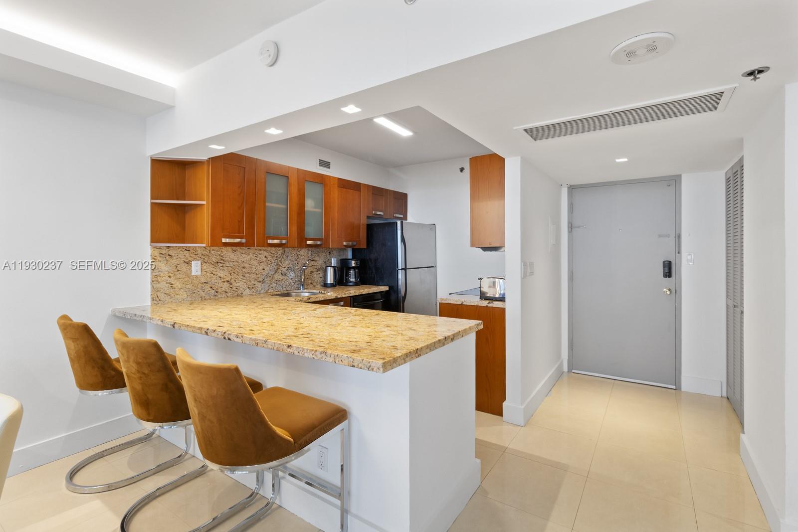 100 Lincoln Road, Unit 543 Miami Beach, FL 33139 - Photo 4 of 17 a kitchen with stainless steel appliances kitchen island granite countertop a sink and cabinets
