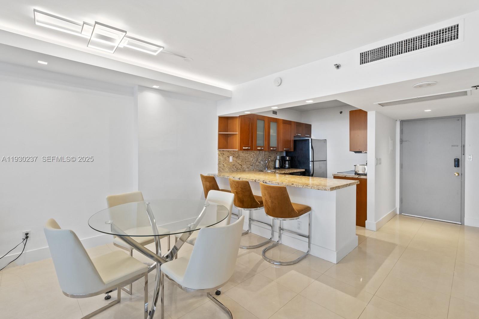 100 Lincoln Road, Unit 543 Miami Beach, FL 33139 - Photo 8 of 17 a kitchen with a dining table chairs and a sink