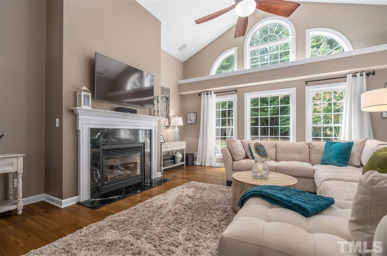 1520 Wood Spring Court Raleigh, NC 27614 - Photo 4 of 30 a living room with furniture a flat screen tv and a fireplace