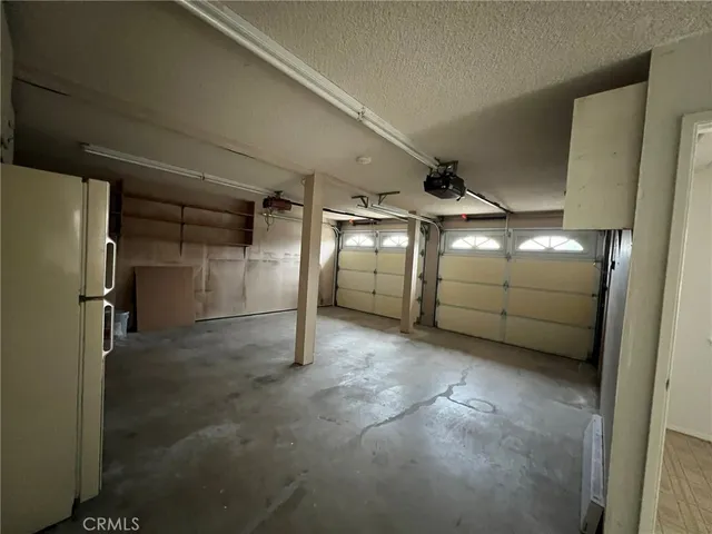a view of a backyard with large trees and wooden fence