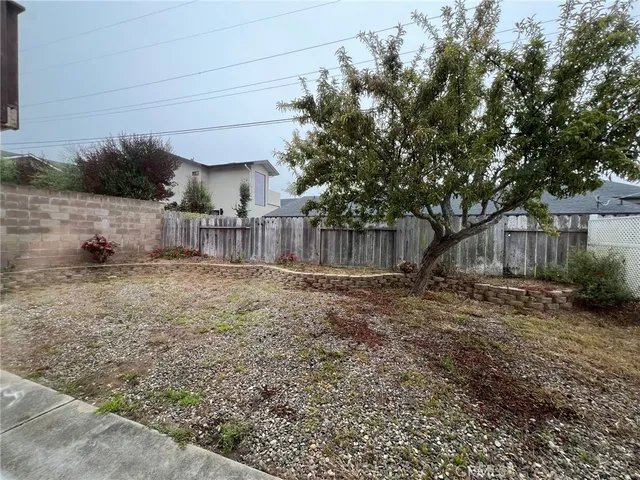 a view of a backyard with wooden fence