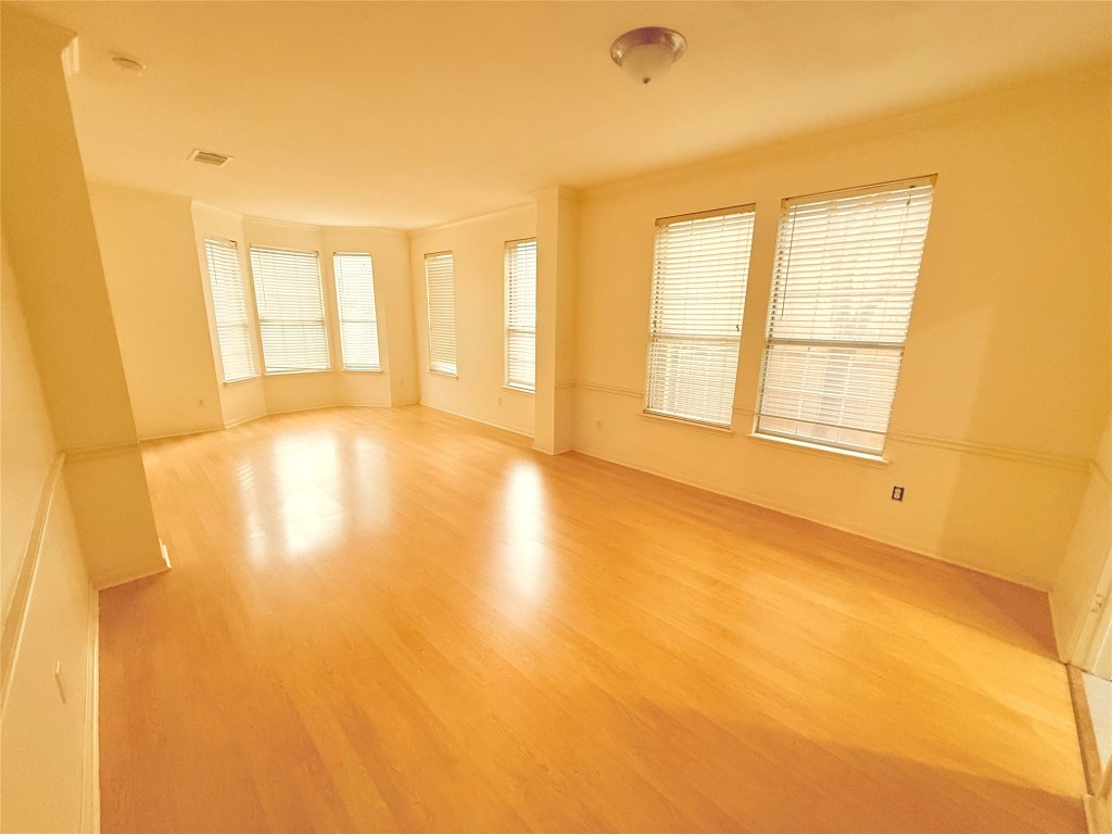 2438 Falcon Drive Round Rock, TX 78681 - Photo 2 of 18 a view of an empty room with a window and wooden floor