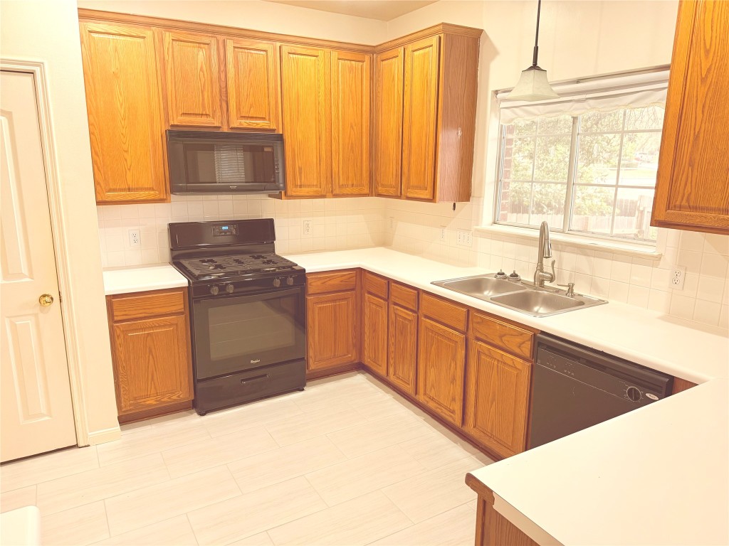 2438 Falcon Drive Round Rock, TX 78681 - Photo 3 of 18 a kitchen with granite countertop a sink and a stove