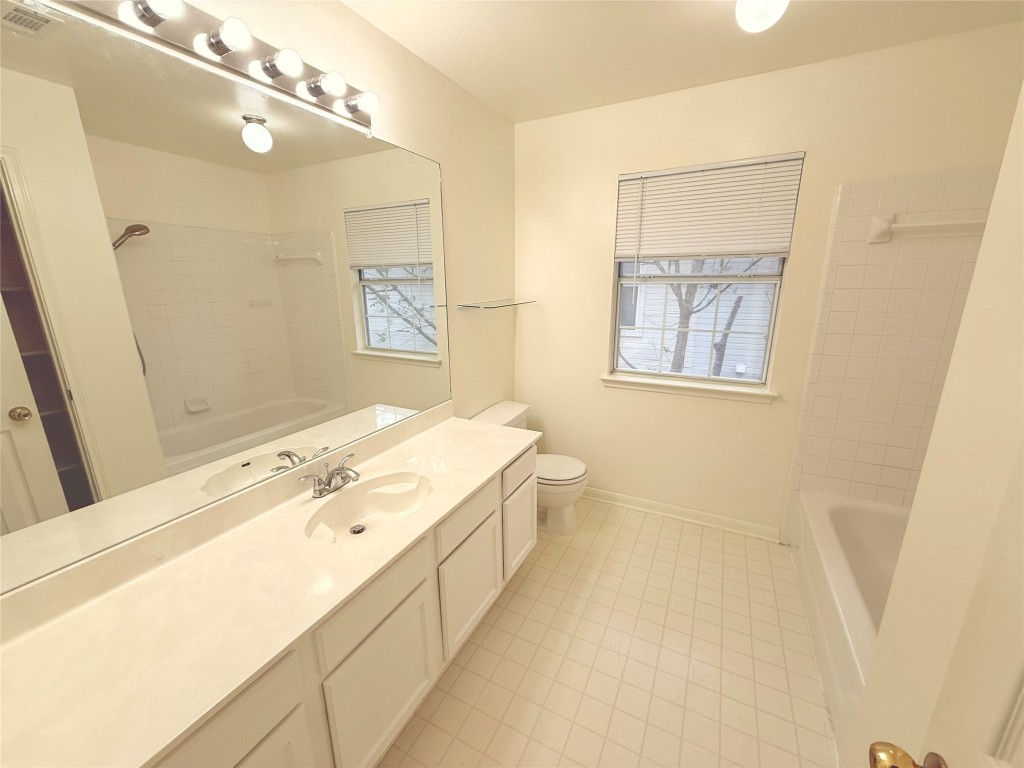 2438 Falcon Drive Round Rock, TX 78681 - Photo 10 of 18 a spacious bathroom with a granite countertop sink a large mirror a shower and a bathtub