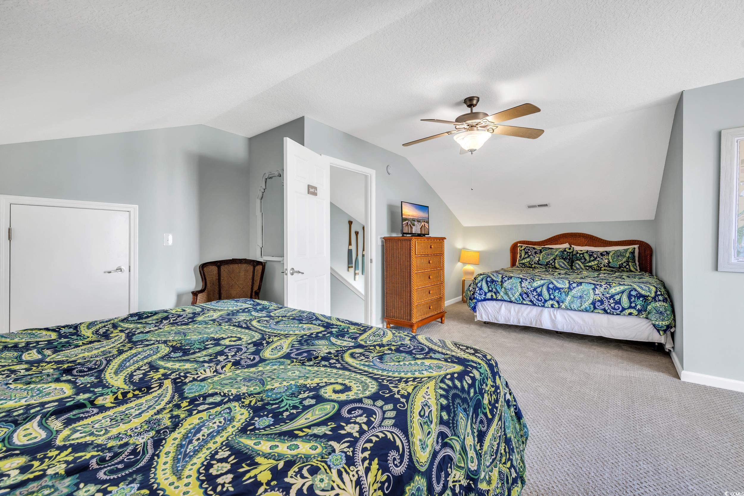 512 North Ocean Boulevard Surfside Beach, SC 29575 - Photo 19 of 39 Bedroom with ceiling fan, a textured ceiling, carpet flooring, baseboards, and vaulted ceiling