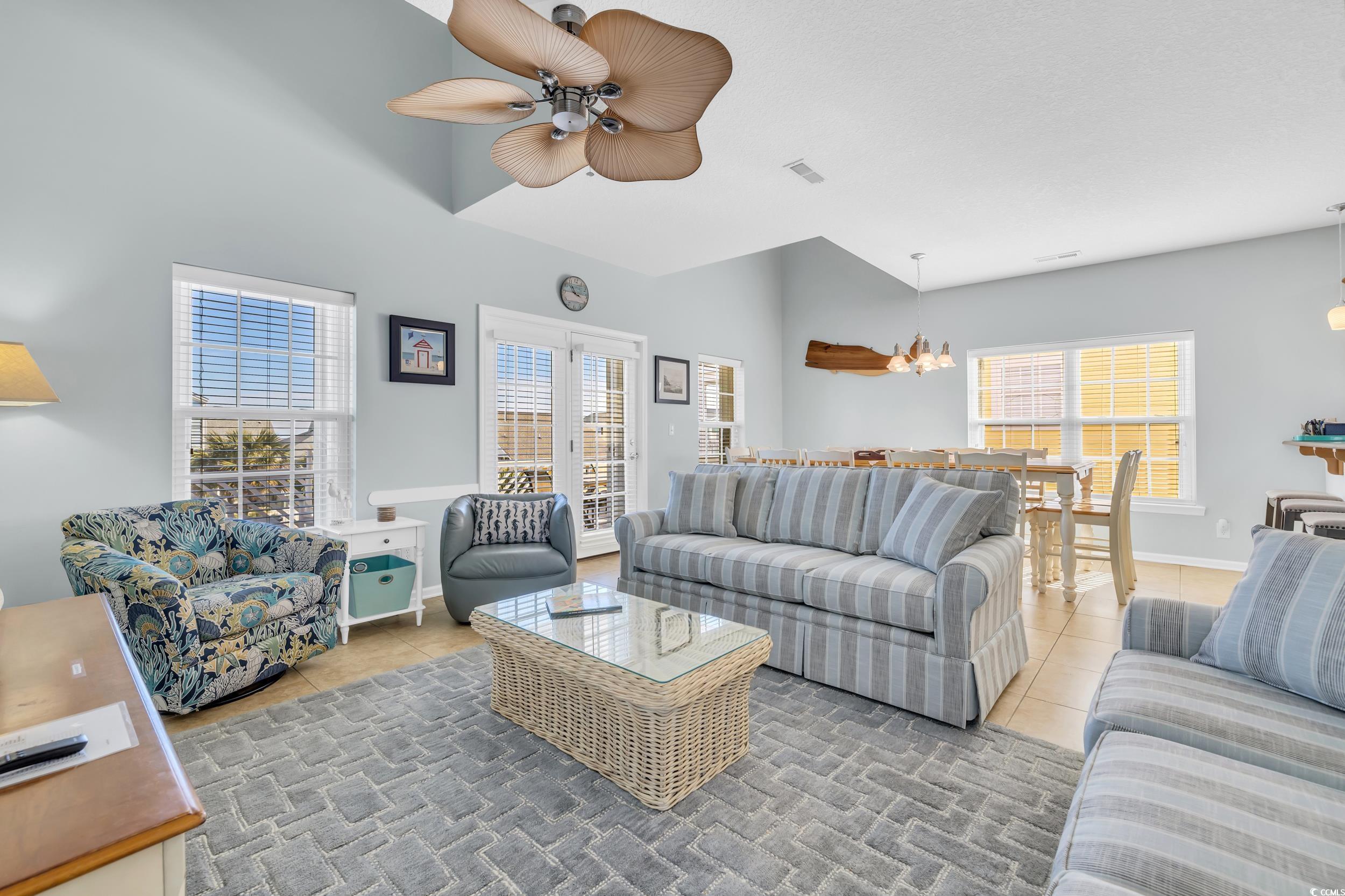 512 North Ocean Boulevard Surfside Beach, SC 29575 - Photo 3 of 39 Tiled living room featuring a healthy amount of sunlight, visible vents, baseboards, and ceiling fan with notable chandelier