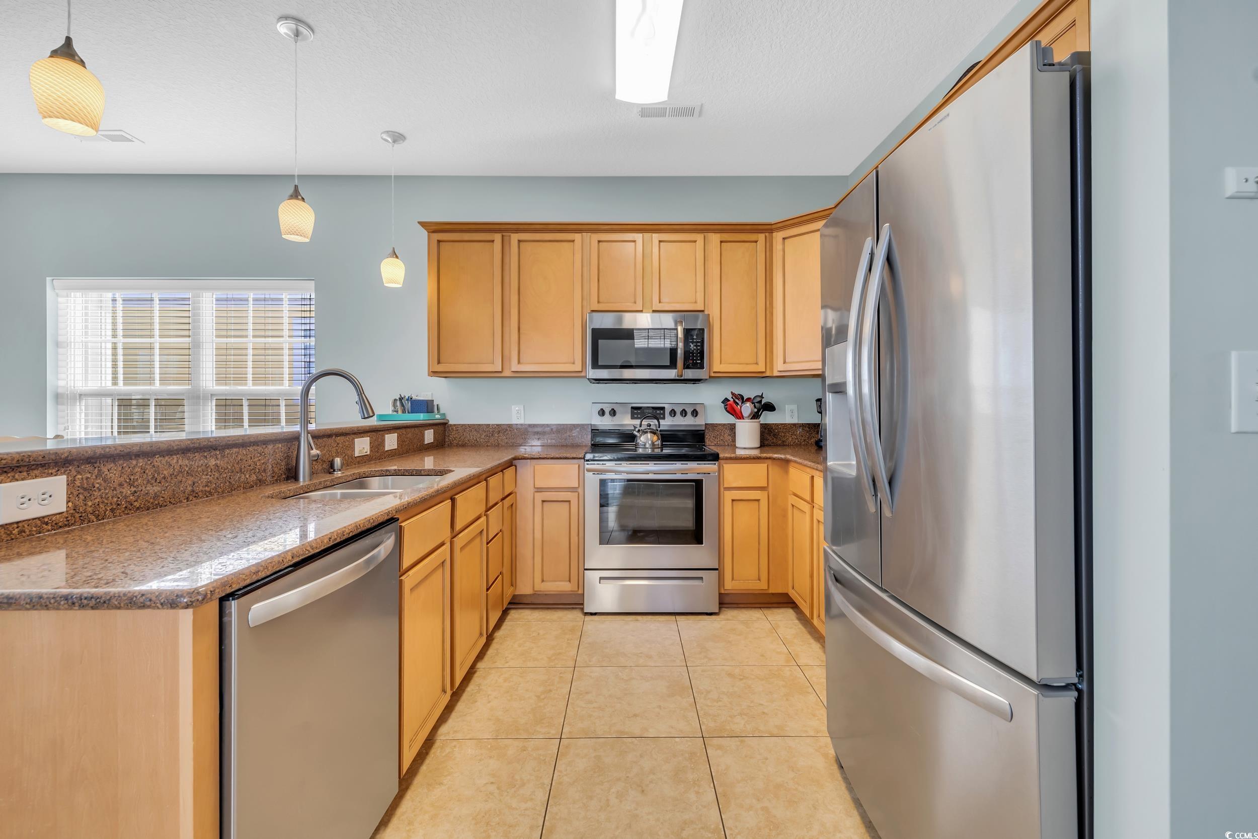512 North Ocean Boulevard Surfside Beach, SC 29575 - Photo 32 of 39 Kitchen with light tile patterned floors, a peninsula, a sink, appliances with stainless steel finishes, and decorative light fixtures
