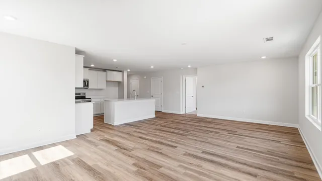 a view of a kitchen with white cabinets stainless steel appliances and window