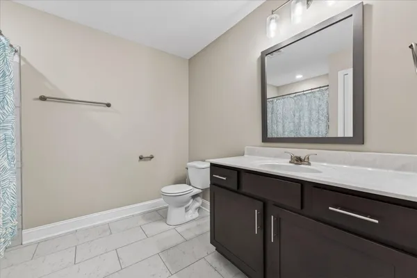 a bathroom with a toilet a sink a mirror and a shower