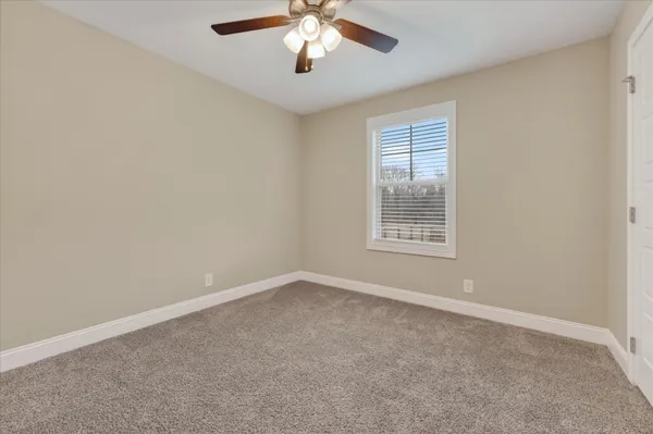 an empty room with a window and a fan