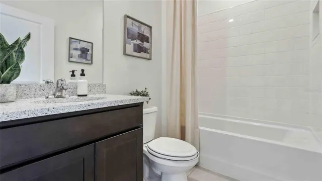 a bathroom with a granite countertop sink toilet and a bathtub