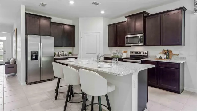 a kitchen with stainless steel appliances a sink stove refrigerator and cabinets
