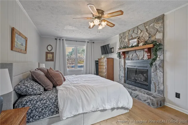 a bedroom with a bed a fireplace and a window
