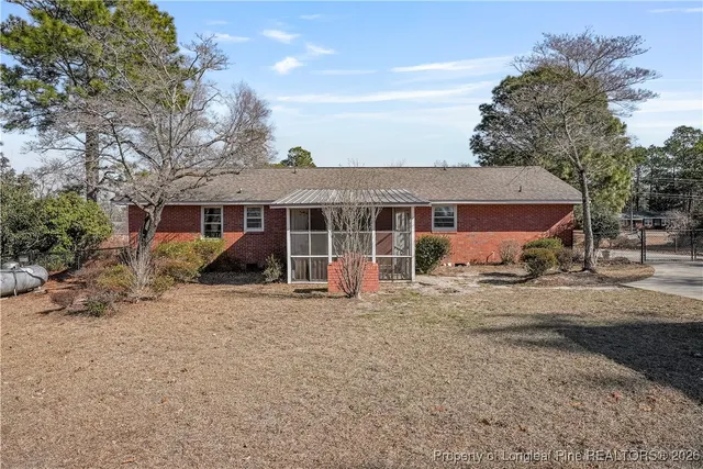a view of a house with a yard and large tree
