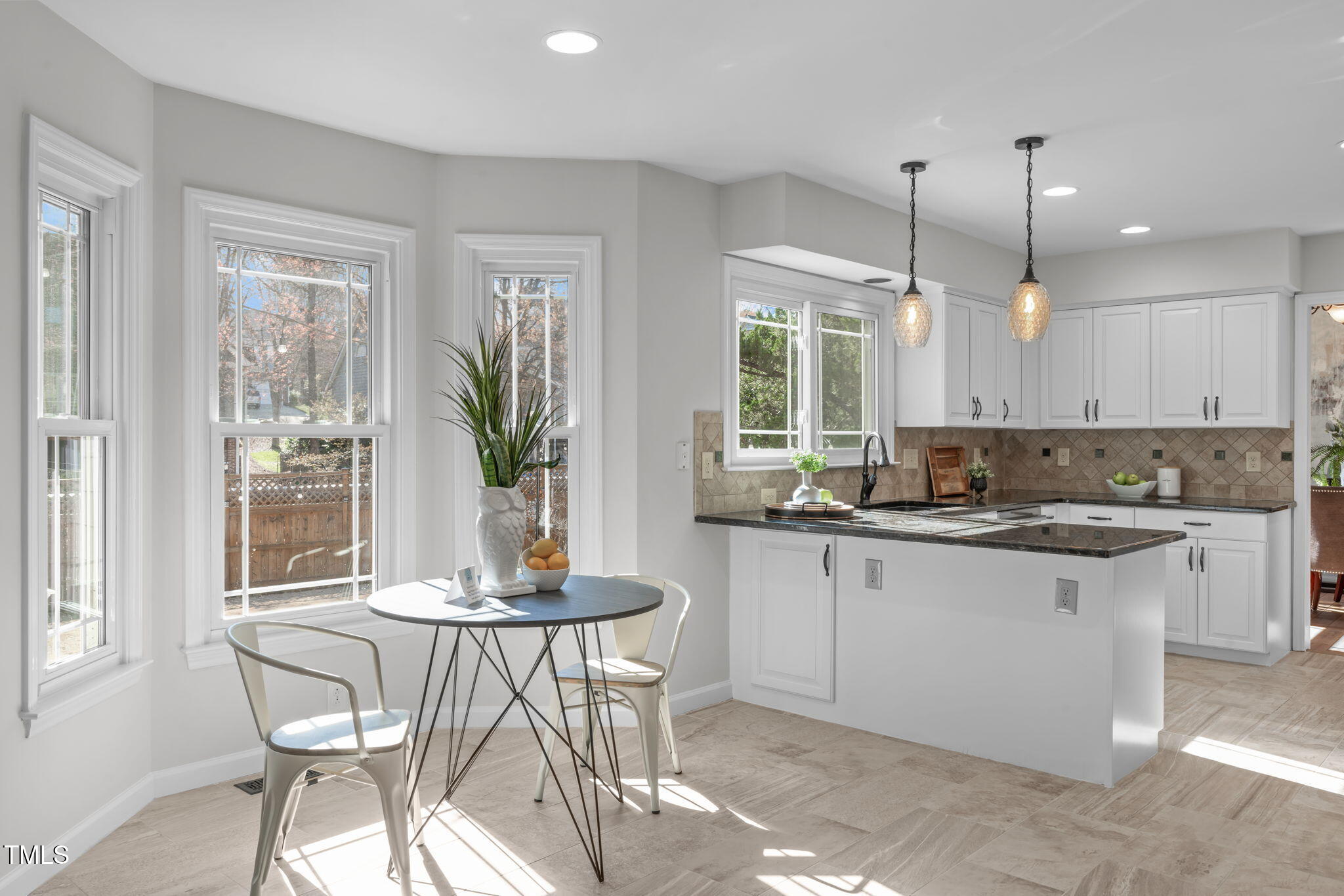 109 Covington Square Drive Cary, NC 27513 - Photo 9 of 41 a kitchen with kitchen island granite countertop a table chairs sink and cabinets