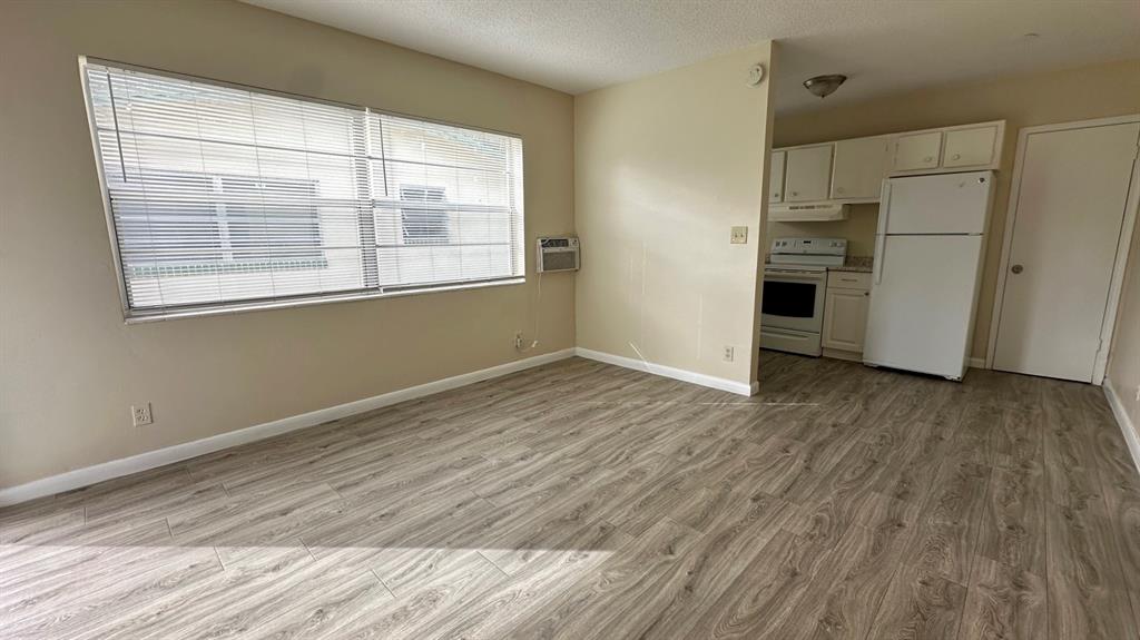 a view of a kitchen with wooden floor and electronic appliances