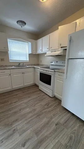 a kitchen with stainless steel appliances granite countertop a stove a sink and a refrigerator