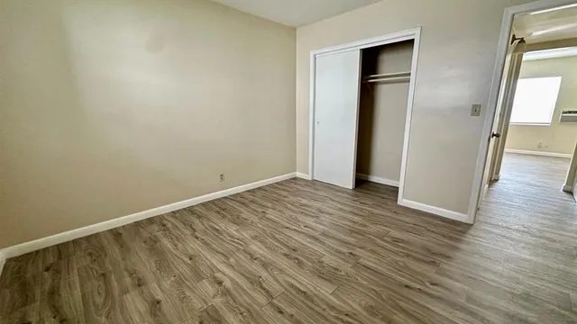 an empty room with wooden floor and closet