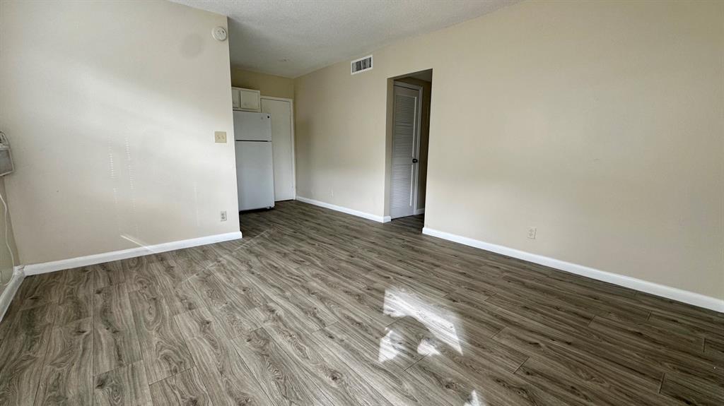 719 Southeast 16th Street, Unit 5 Fort Lauderdale, FL 33316 - Photo 10 of 12 a view of an empty room with wooden floor and a window