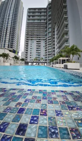 a front view of multi story residential apartment building with yard and entryway