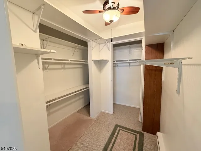 a view of walk in closet with a fan