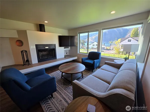a living room with furniture a fireplace and a large window