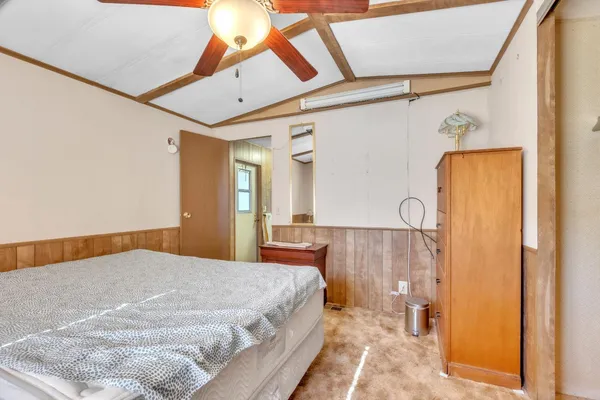 a bedroom with a bed and a dresser with mirror