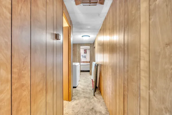 a view of a hallway with wooden shelves