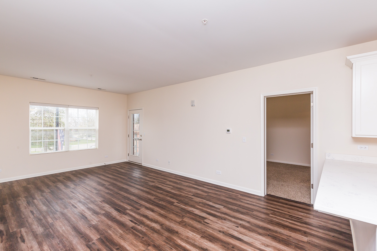 60 West Main Street, Unit 233 Lake Zurich, IL 60047 - Photo 6 of 15 an empty room with wooden floor and windows