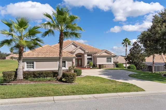 a kitchen with stainless steel appliances granite countertop a refrigerator a sink dishwasher a oven and a dining table with wooden floor