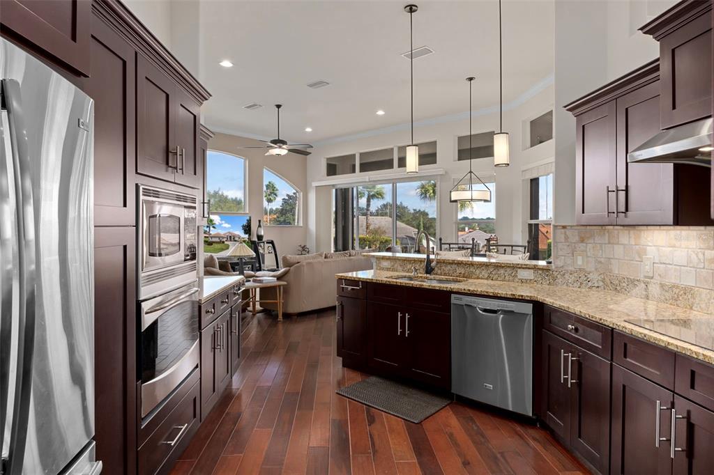 1601 North Tee Time Terrace Hernando, FL 34442 - Photo 3 of 68 a kitchen with stainless steel appliances granite countertop a refrigerator a sink dishwasher a oven and a dining table with wooden floor