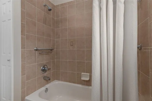 a bathroom with a tub a shower and a window