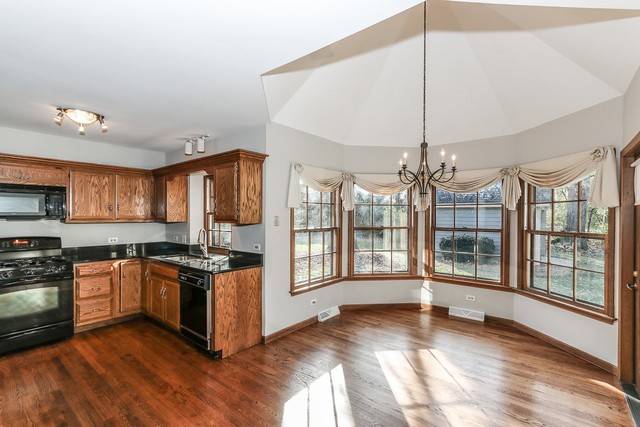 102 Wilcox Drive Bartlett, IL 60103 - Photo 11 of 30 a kitchen with stainless steel appliances granite countertop a stove and a wooden floors