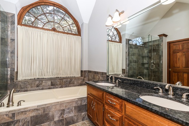 102 Wilcox Drive Bartlett, IL 60103 - Photo 16 of 30 a bathroom with a granite countertop tub sink and mirror