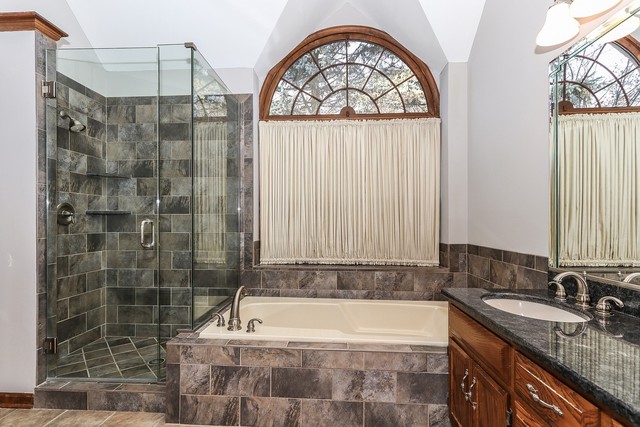 102 Wilcox Drive Bartlett, IL 60103 - Photo 17 of 30 a bathroom with a granite countertop bathtub a sink and a shower