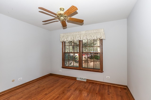 102 Wilcox Drive Bartlett, IL 60103 - Photo 19 of 30 an empty room with wooden floor fan and windows