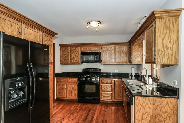 102 Wilcox Drive Bartlett, IL 60103 - Photo 7 of 30 a kitchen with stainless steel appliances granite countertop a stove a sink and a refrigerator