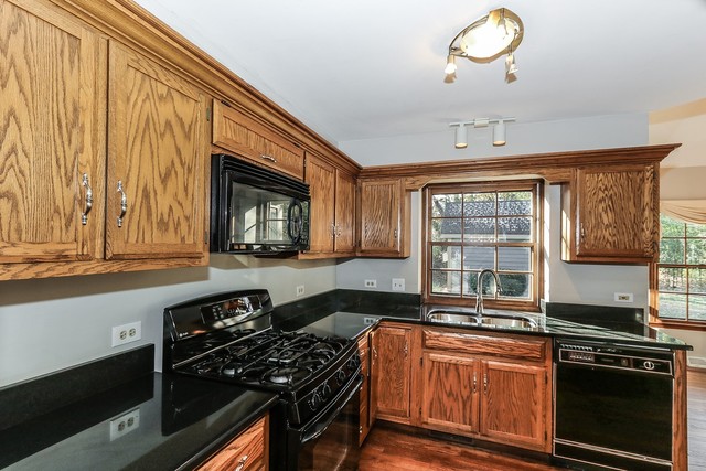 102 Wilcox Drive Bartlett, IL 60103 - Photo 9 of 30 a kitchen with stainless steel appliances granite countertop a stove a sink and a microwave